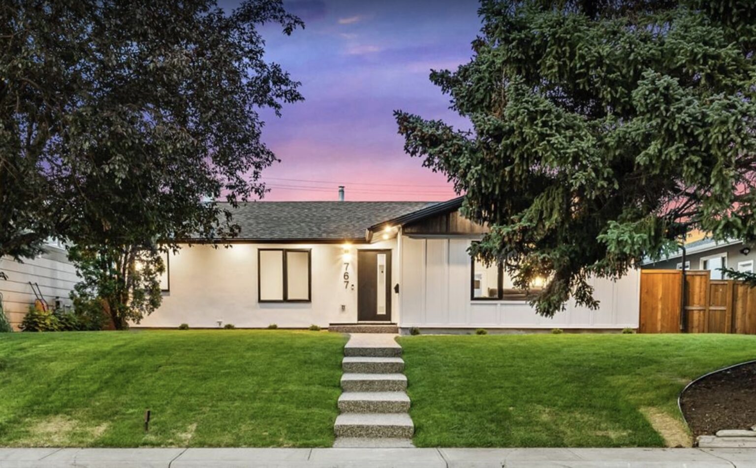 Recently completed Calgary infill home with white exterior and black trim at twilight